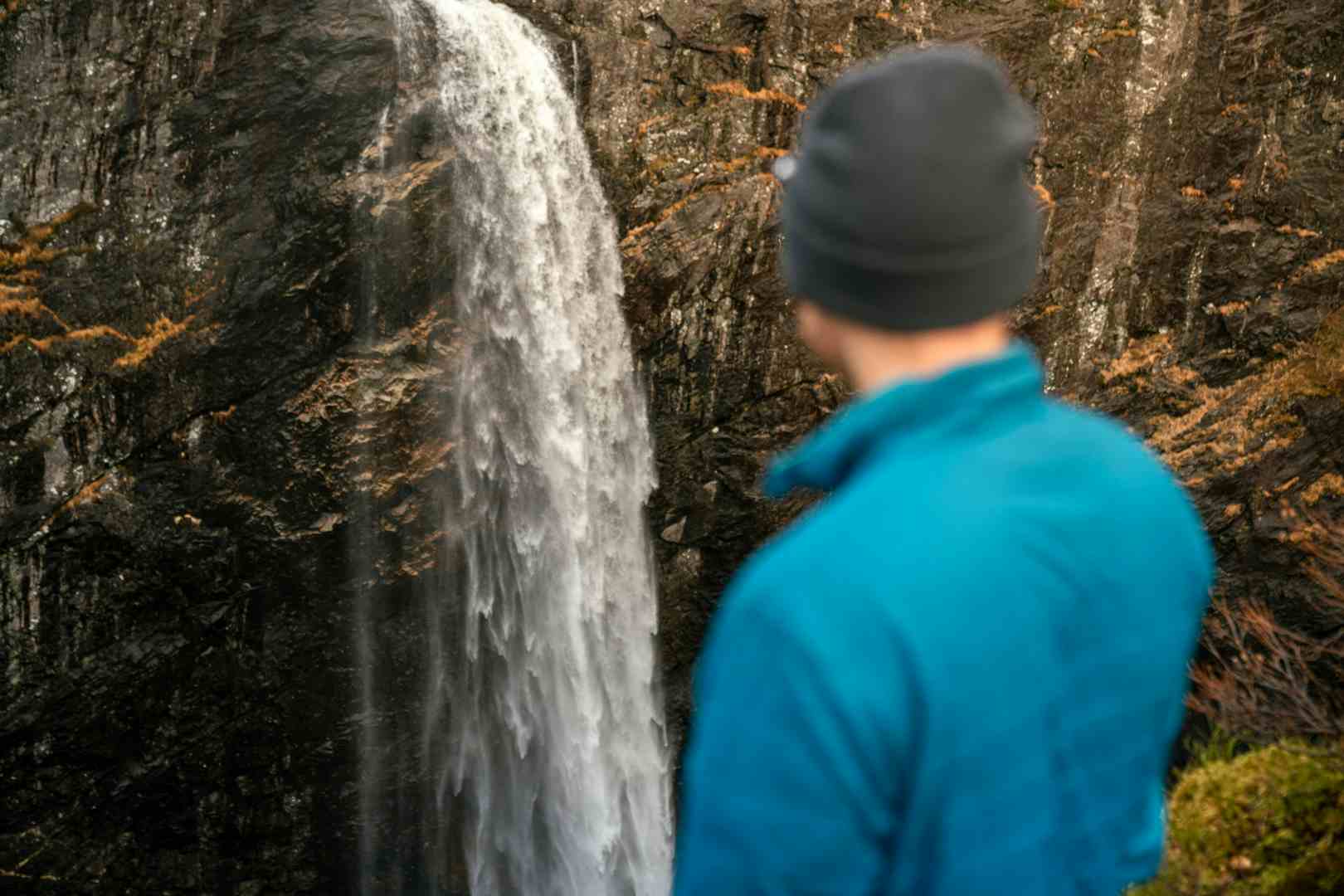 Man watching a waterfall in scenic surroundings in Norway