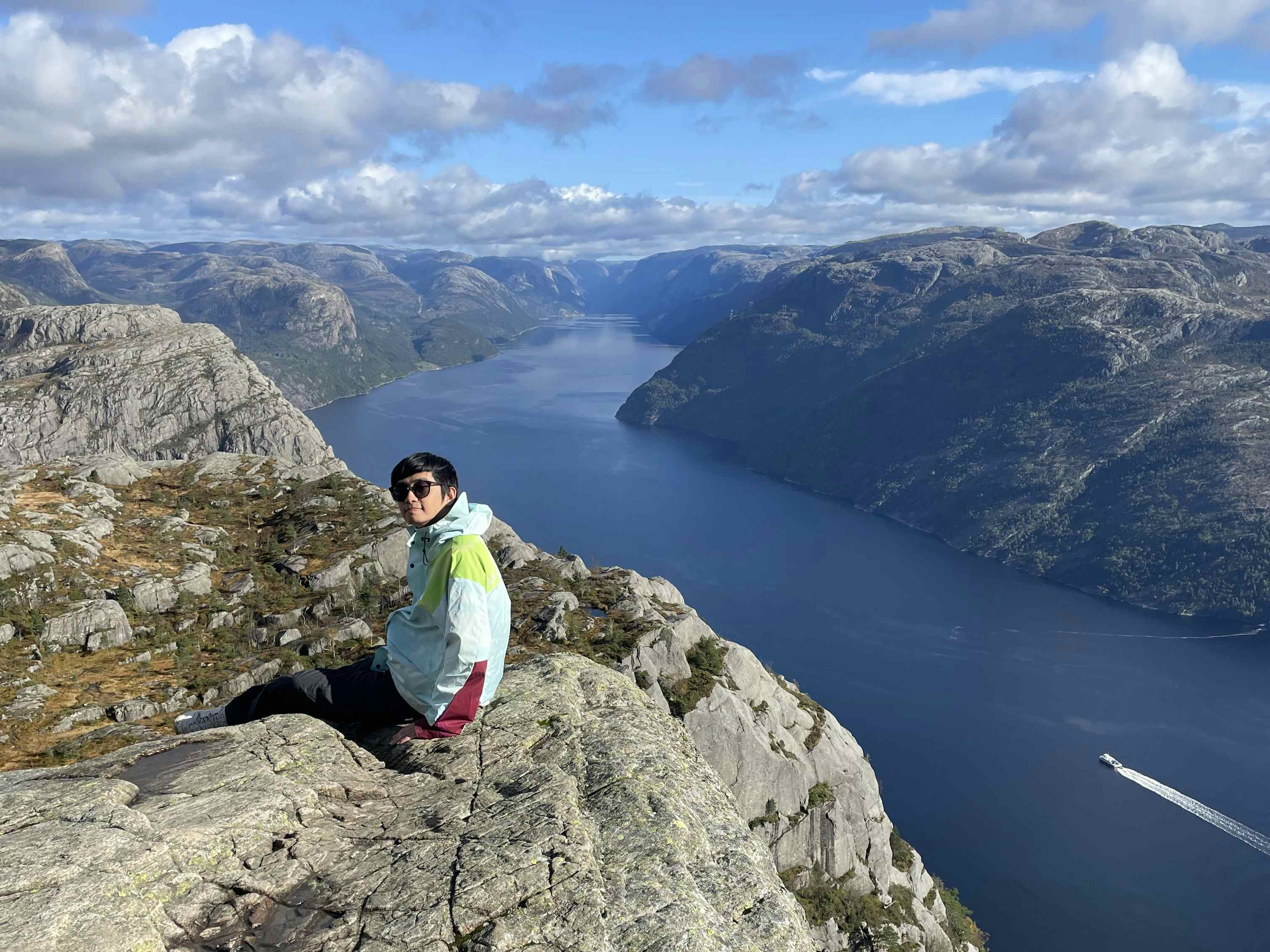 En person som sitter på et berg foran Lysefjorden.