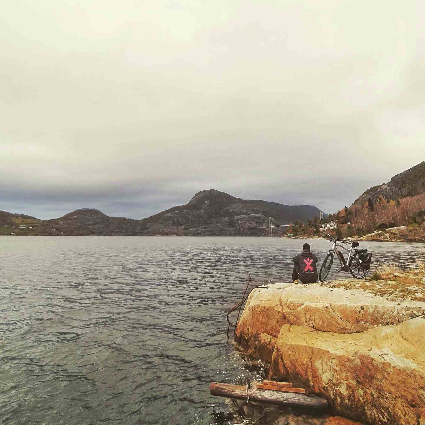 To voksne og to barn som sykler mede Lysefjorden i bakgrunnen.