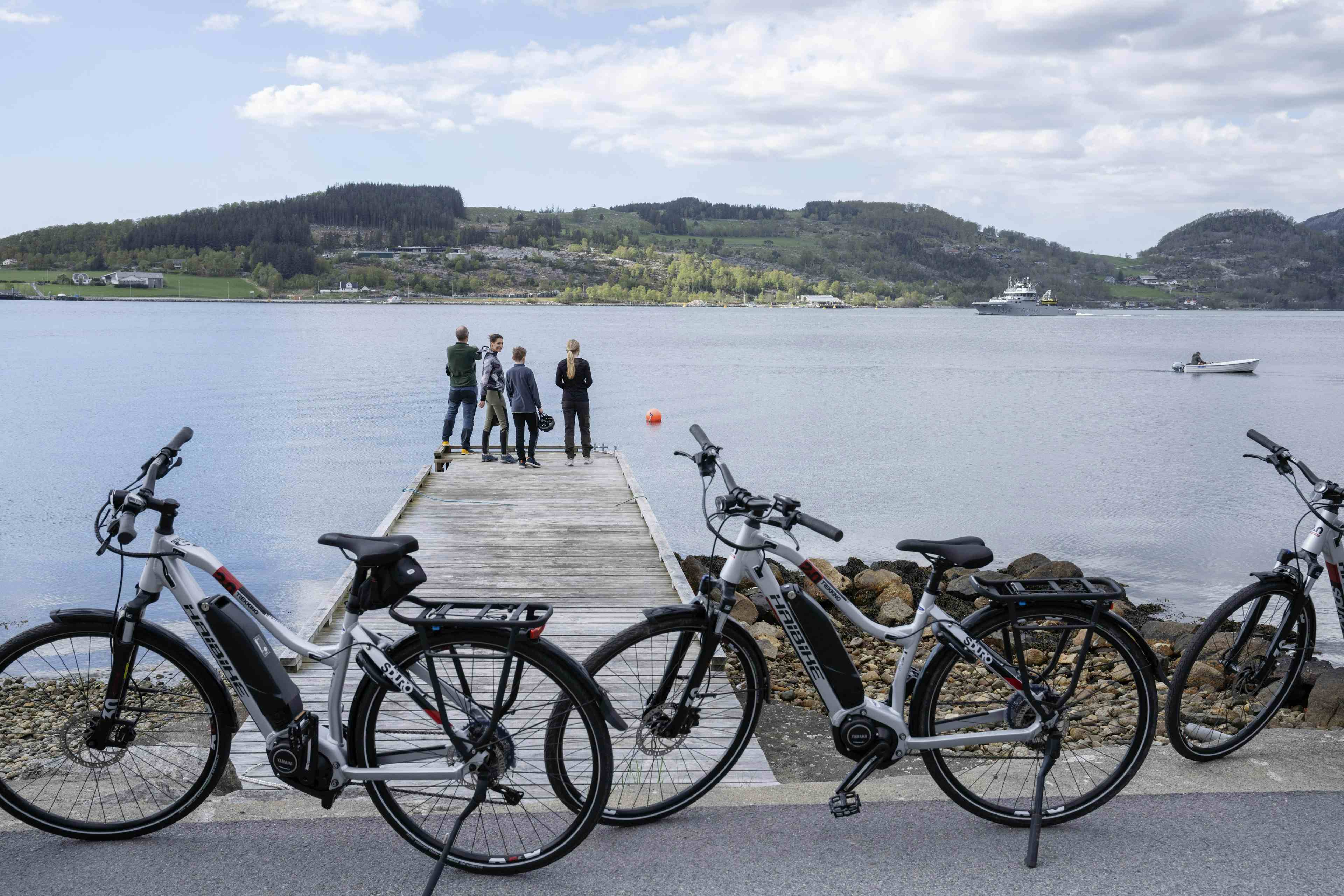 To voksne og to barn som sykler mede Lysefjorden i bakgrunnen.