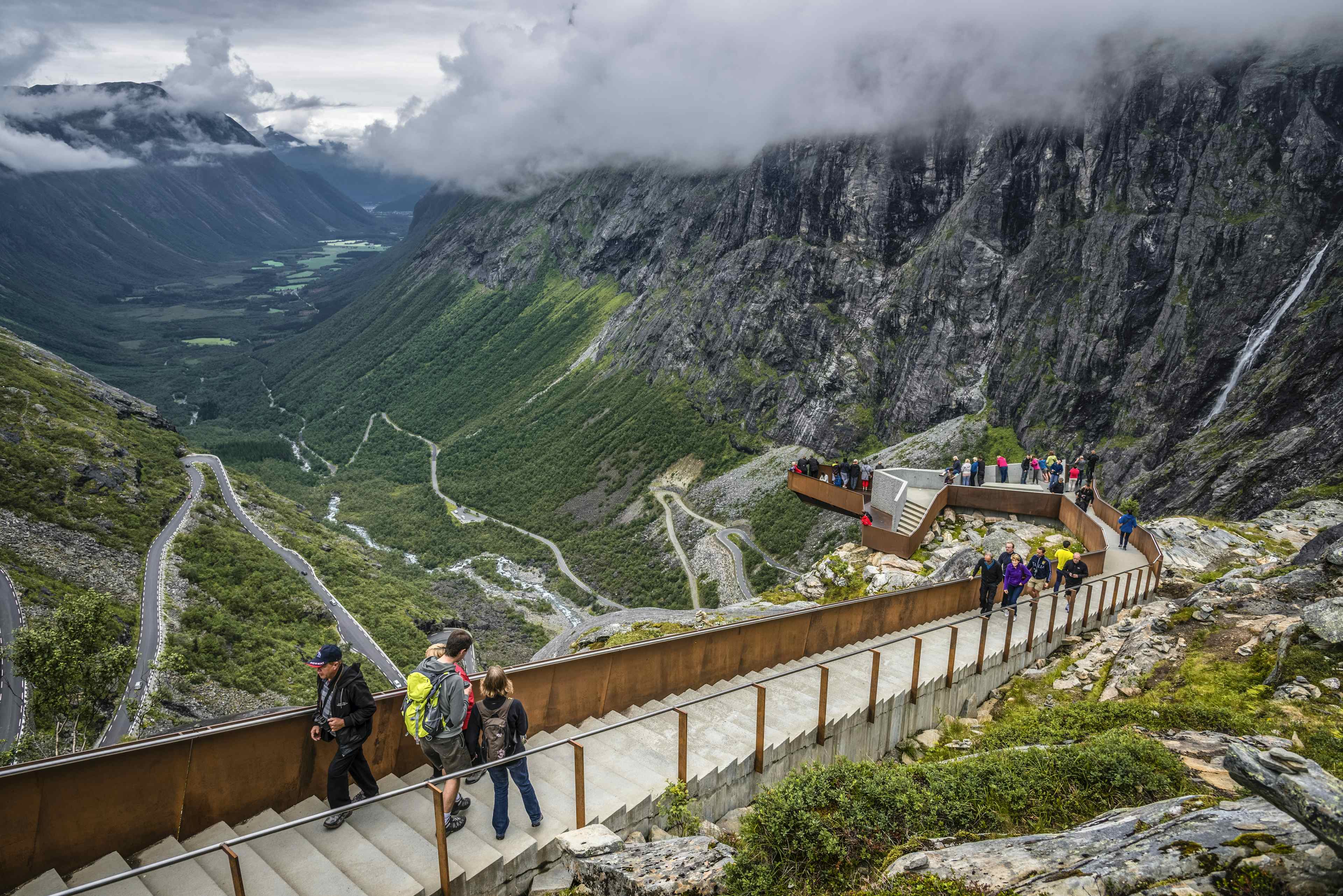 Utsiktsplattform over Trollstigen med en gruppe mennesker som ser på utsikten.