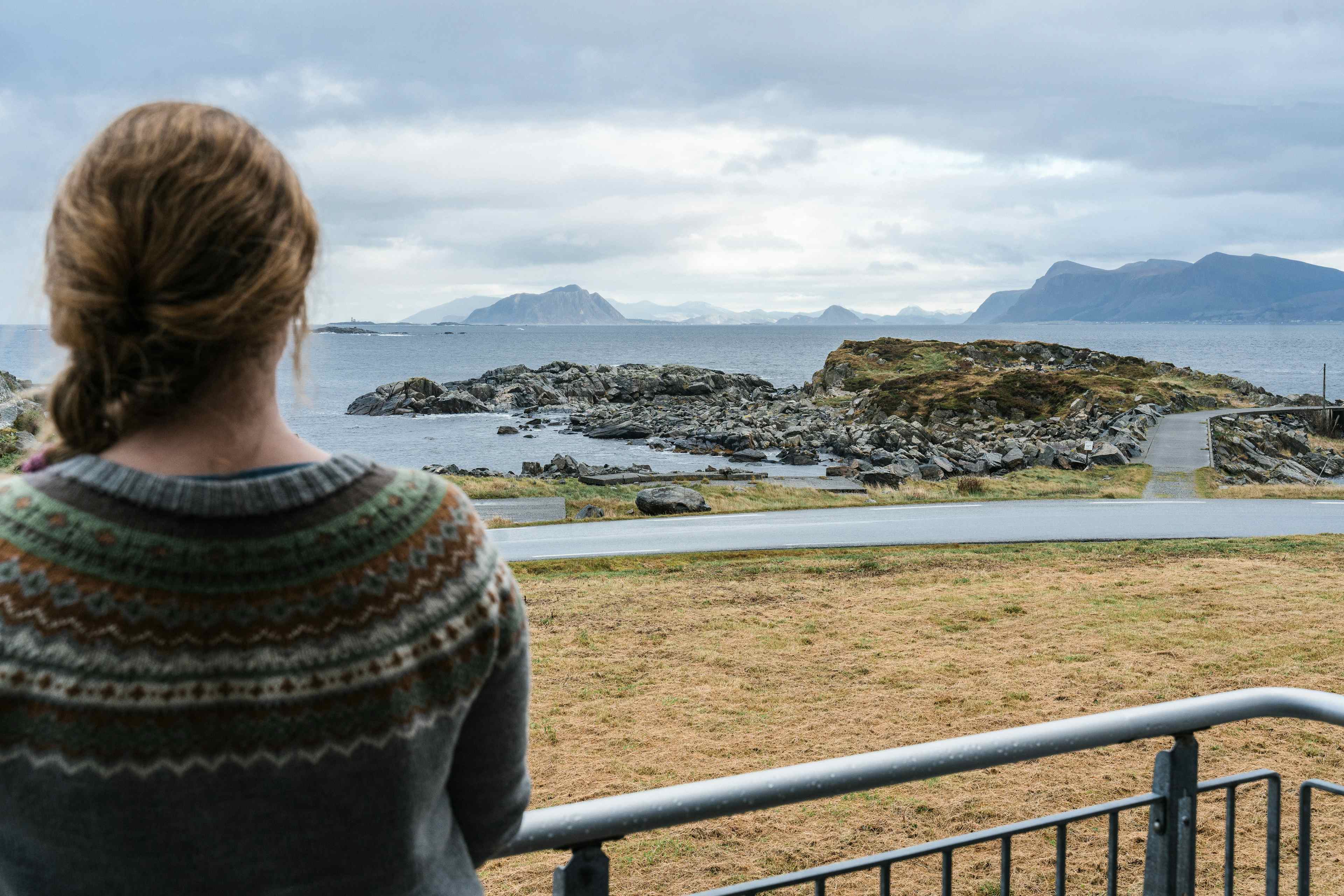 Person på terrassen og nyter utsikta mot fjøra og havet