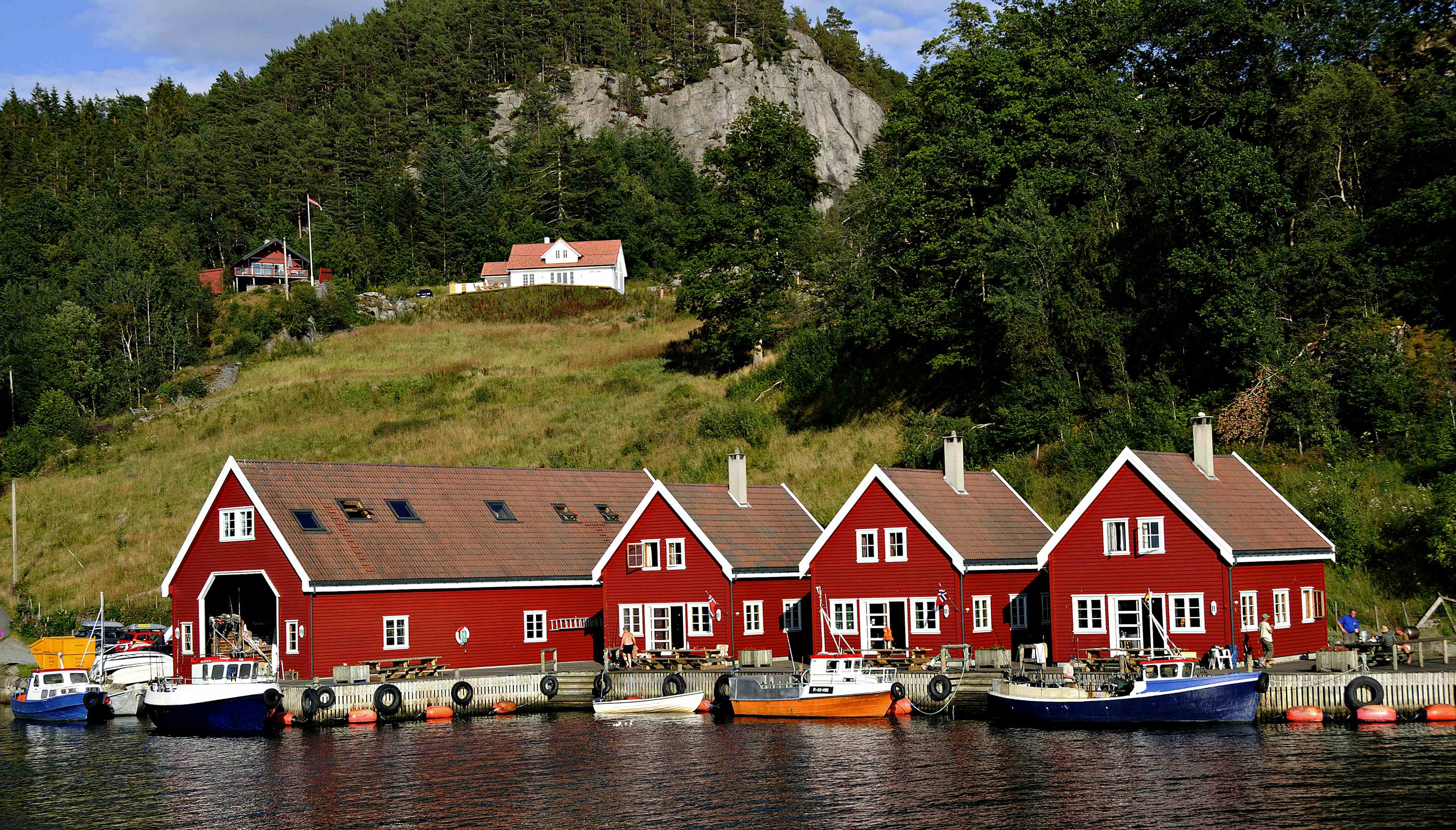 En rekke røde leiligheter helt nede ved sjøen.