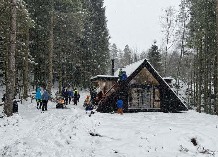 Flere barn og voksne samlet i snøen utenfor dagturhytta Kvilehaugen i Jelsa.