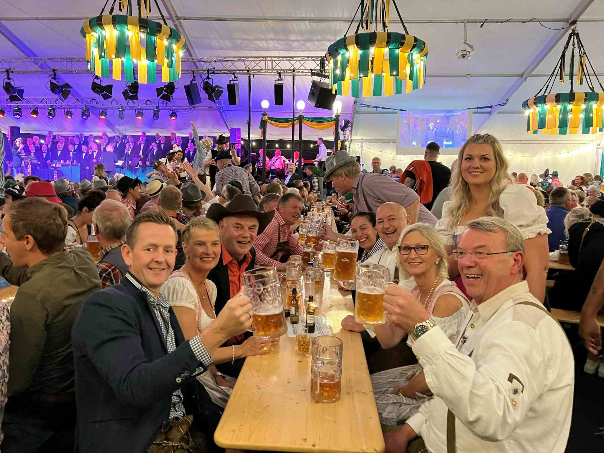 Masser av folk sitter langs langbord med øl på Oktoberfest i Egersund.