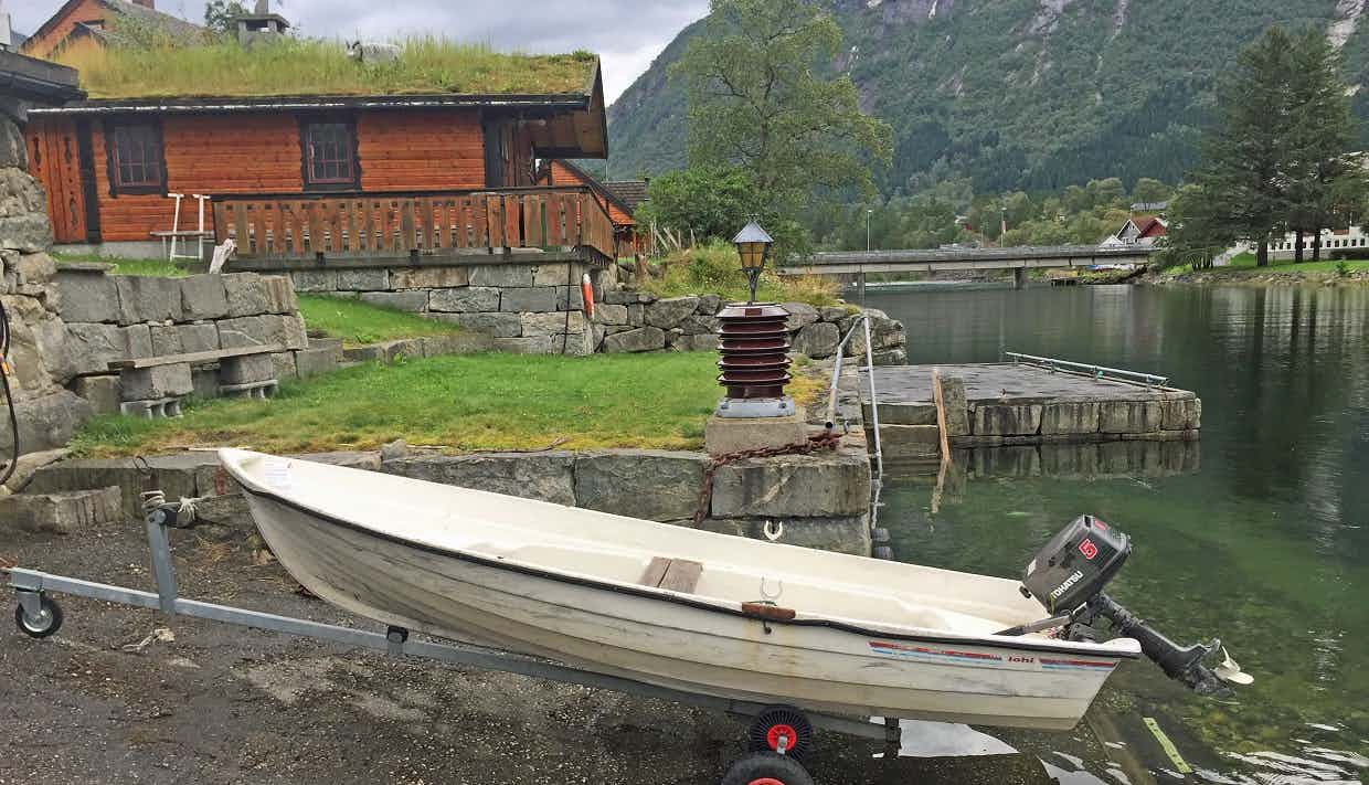 En oversikt over campingplassen som ligger langs en elv og ved siden av en fjord.