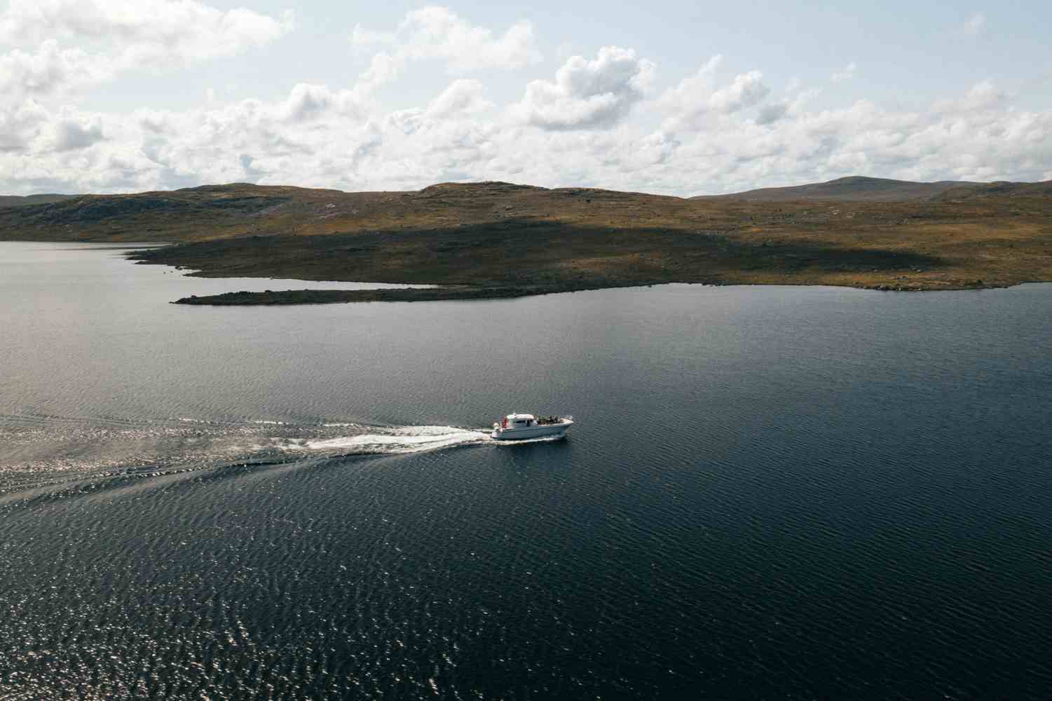 Et dronebilde av båten «Halnekongen» midt på Halnefjorden.