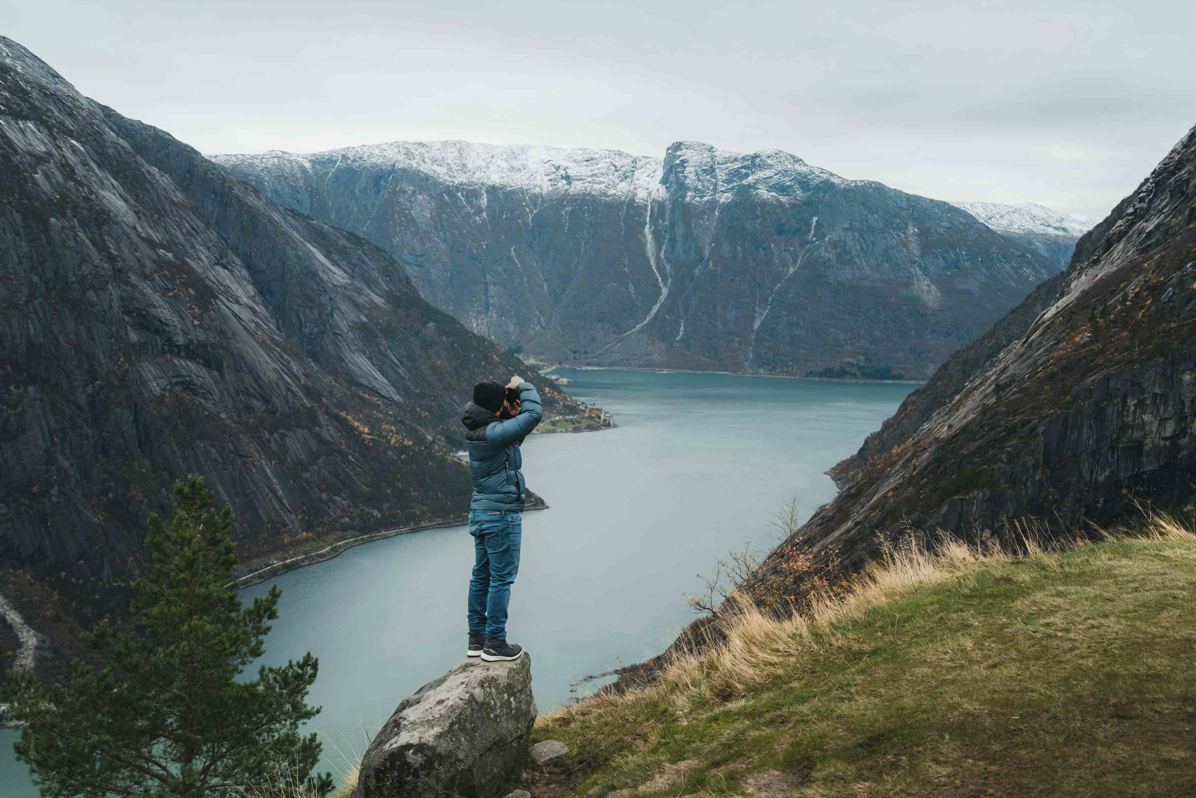 Et bilde fra Kjeåsen som viser en person som står i det fjerne og stirrer på fjorden nedenfor.