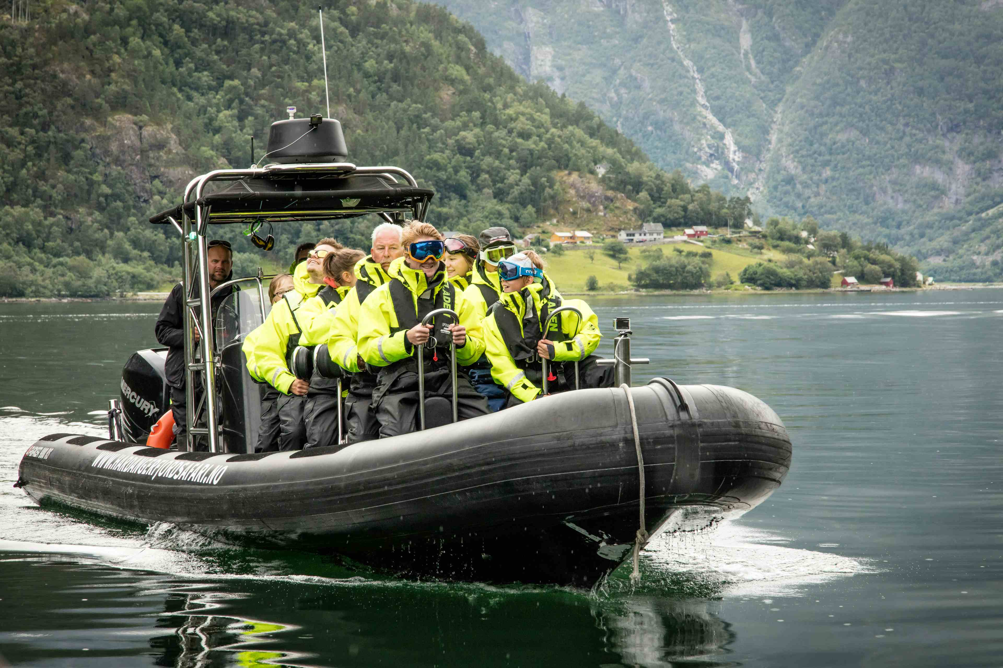 En ribbåt på fjorden, fylt med passasjerer.